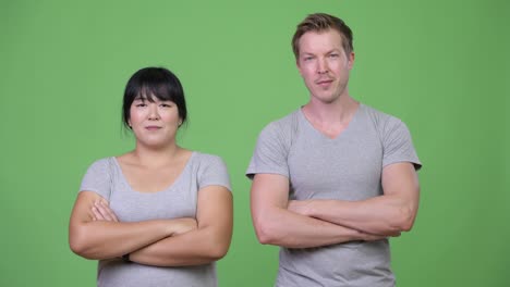 happy young multi-ethnic couple with arms crossed together