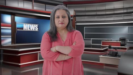 confiada periodista india de alto rango de pie con las manos cruzadas