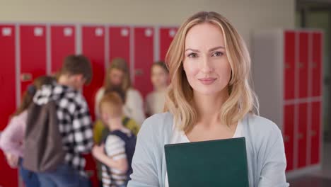 Video-portrait-of-smiling-teacher-standing-in-the-school-corridor