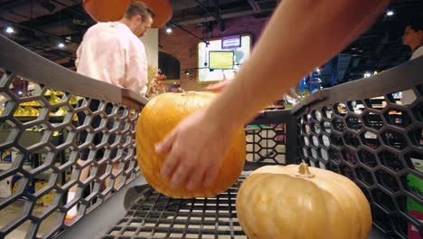 shopping cart with pumpkins and squash at grocery store