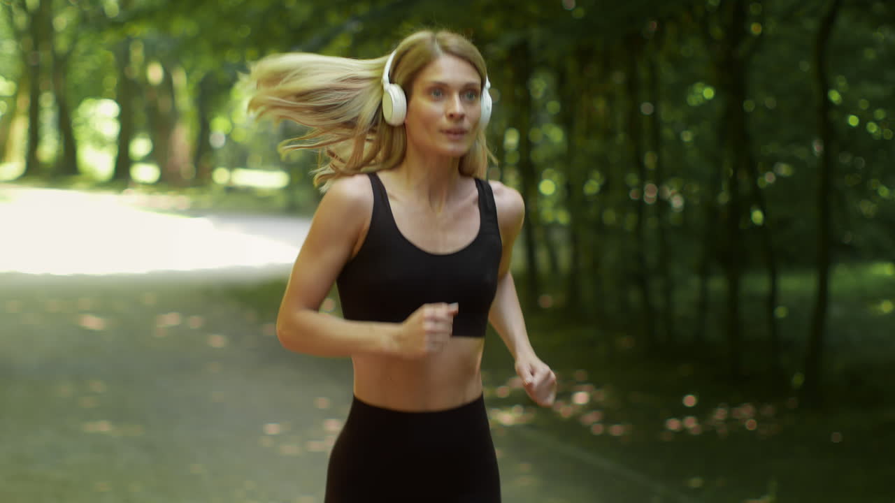Woman jogging in a park with headphones