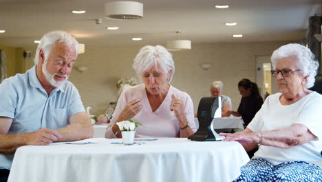 group of seniors playing game of bingo in retirement home