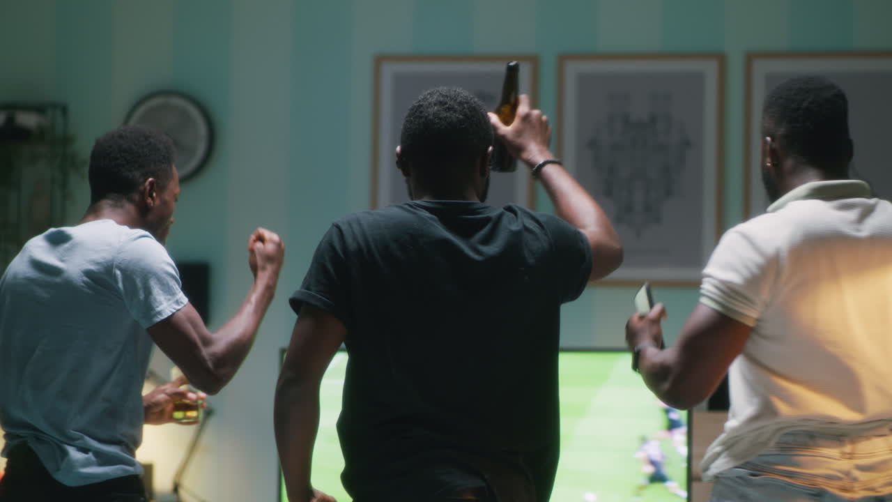 amigos viendo un partido de fútbol en casa