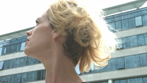 a young business woman  looking around the office buildings surrounding her. concept of looking for a job and the first day at work