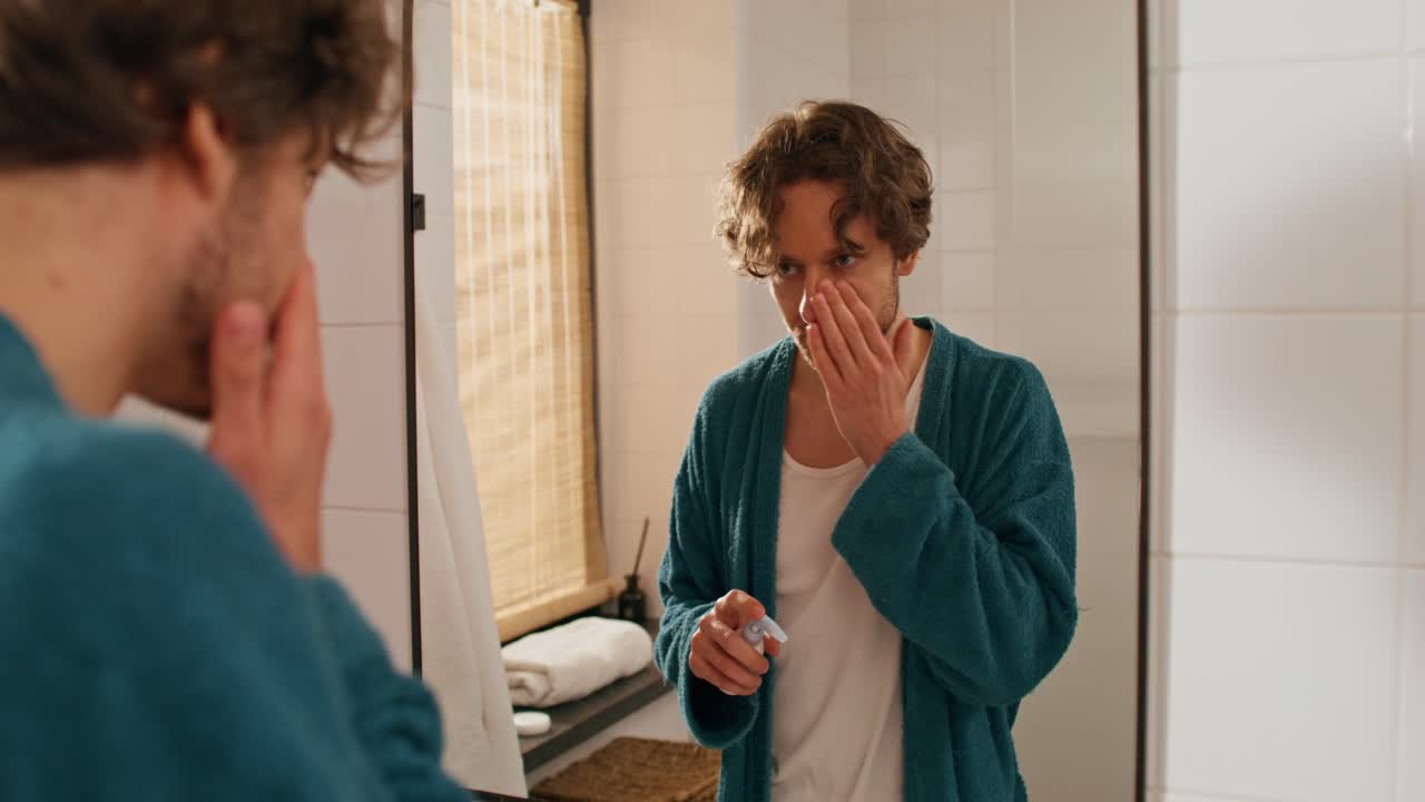 욕실 에서 얼굴 크림 을 적용 하는 남자