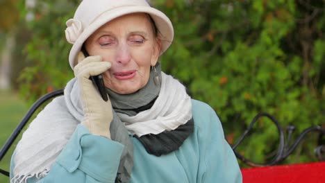 elderly woman talking on a mobile phone outdoors