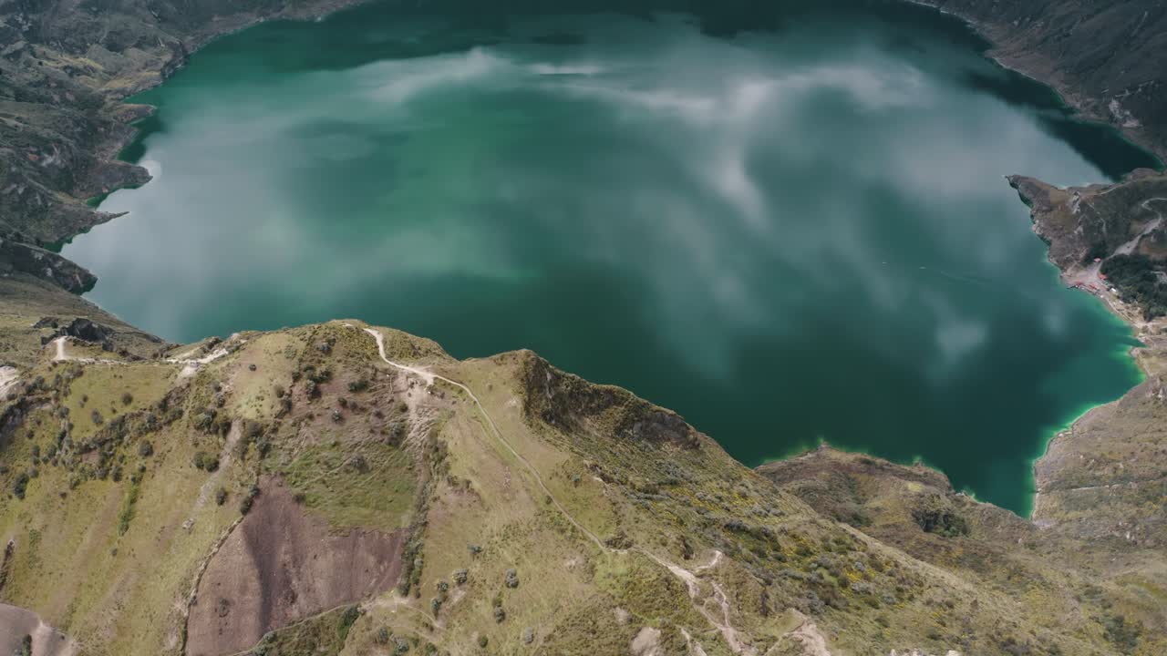 Vista aerea dall'alto di un sentiero su una cima montuosa e un idilliaco lago craterico nella valle dopo un'eruzione