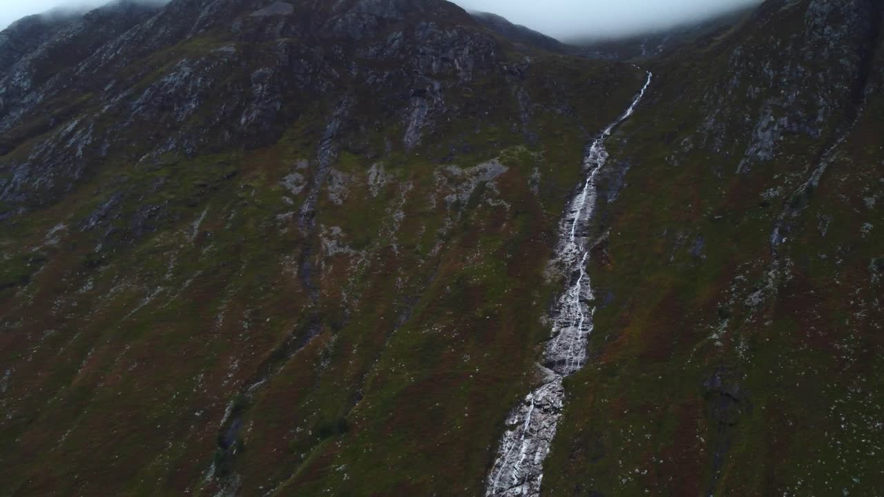 un primer plano aéreo de drones en la cascada de ben nevis el flujo de agua el paisaje nublado de escocia