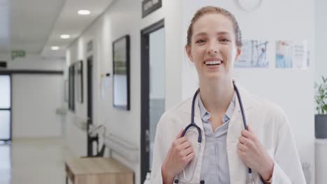 Portrait-of-happy-female-doctor-with-stethoscope-smiling-in-hospital,-in-slow-motion,-copy-space