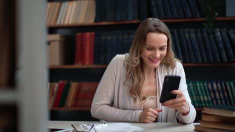 overjoyed business woman good news celebrating win career opportunity smartphone message at library