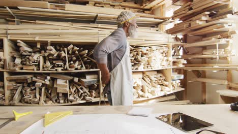 African-american-male-carpenter-wearing-an-apron-in-a-carpentry-shop