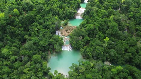 aerial establishing of cascadas roberto barrios waterfalls surrounded by lush tropical forest, turquoise green pools