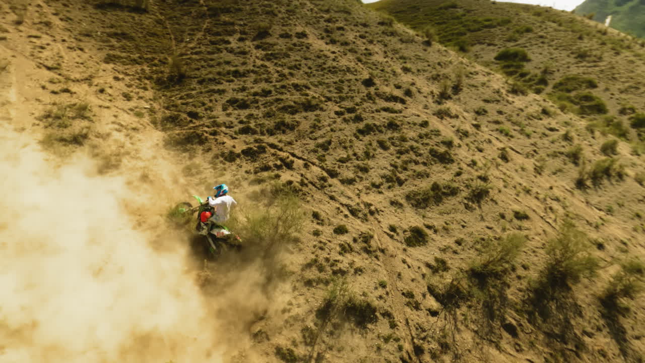 el piloto tiene problemas con el deslizamiento de la motocicleta en la colina del dron fpv. el deportista se ocupa de un accidente de motocicleta durante las carreras en las tierras altas del desierto. problemas offroad