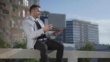 Businessman-using-laptop-for-video-call-outdoors.-Freelancer-working-on-laptop