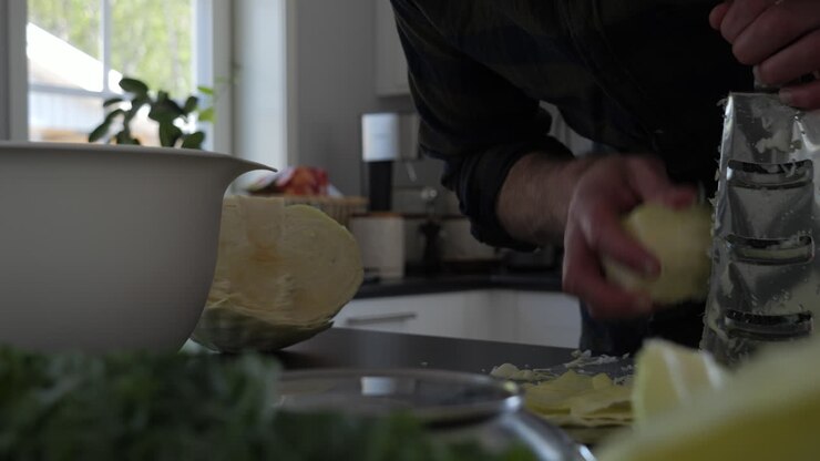 Uomo che trita cavolo per crauti o kimchi, movimento carrello, primo piano.