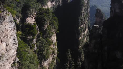 Zhangjiajie,-Wulingyuan-Hunan-China-Montaña-Agujas-De-Roca-Y-Vegetación-De-Acantilados,-Retroceso-Aéreo-Inclinado-Hacia-Arriba