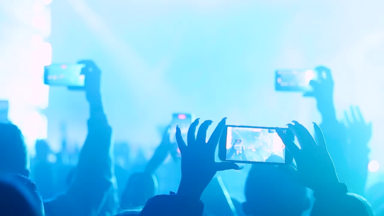 People filming live stage with smartphones during performance