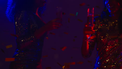 Close-Up-Of-Two-Women-In-Nightclub-Bar-Or-Disco-Dancing-And-Drinking-Alcohol-With-Paper-Confetti-1