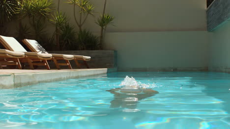 woman dipping into swimming pool