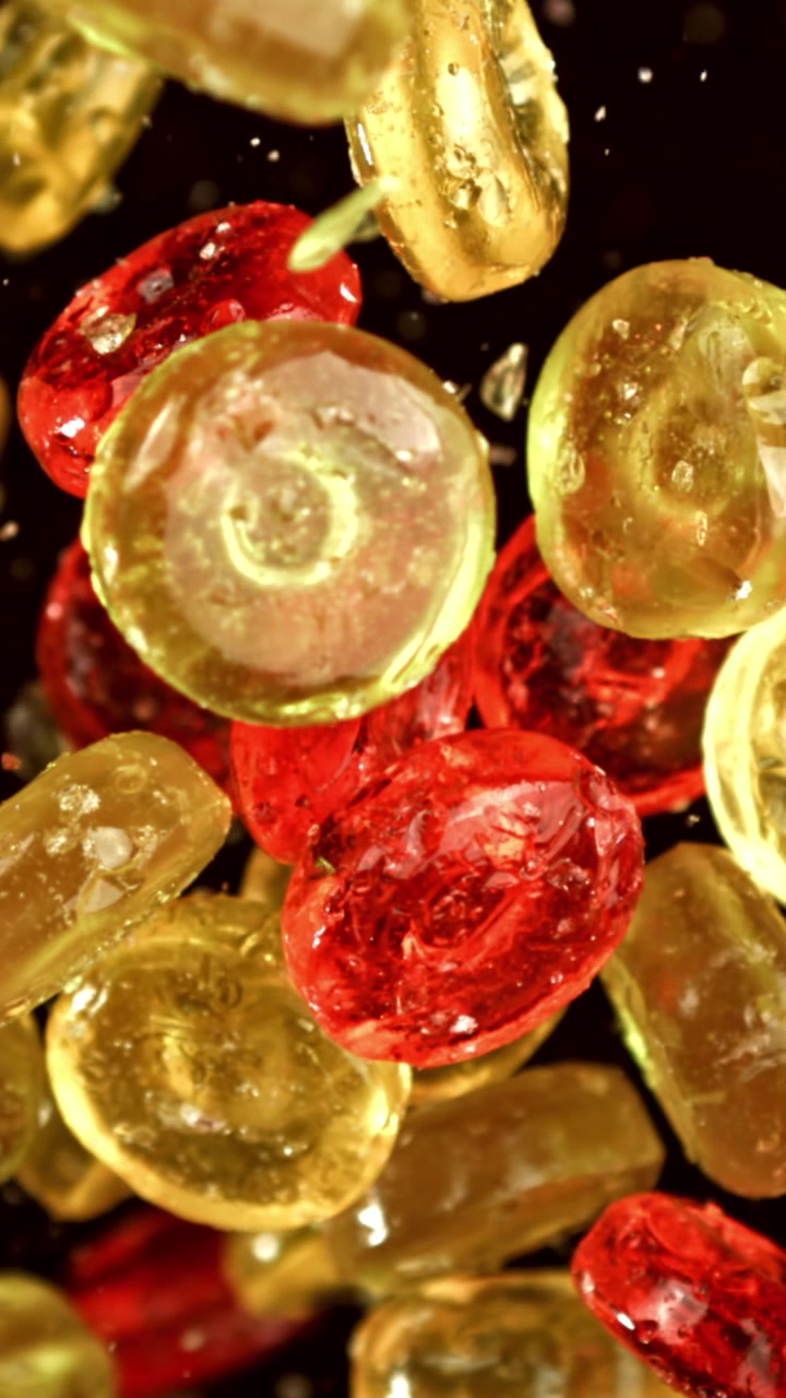 Caramelle rosse e gialle che cadono al rallentatore