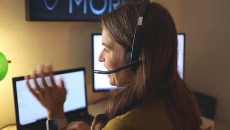 primer plano de una chica que trabaja desde casa en un escritorio y habla con el cliente por teléfono