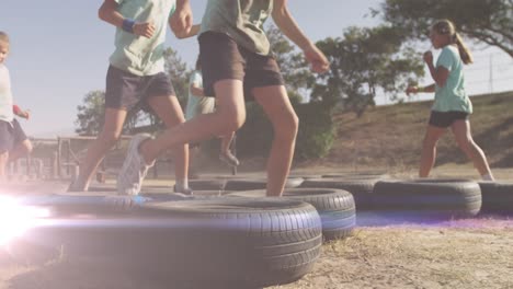 animation of light spots over diverse schoolchildren exercising on obstacle course