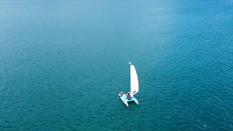 A-aerial-view-of-a-small-sailboat-in-the-blue-of-the-Caribbean-waters-on-a-sunny-day