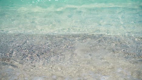 woman spreading sunscreen on her arm at the beach on a hot sunny day