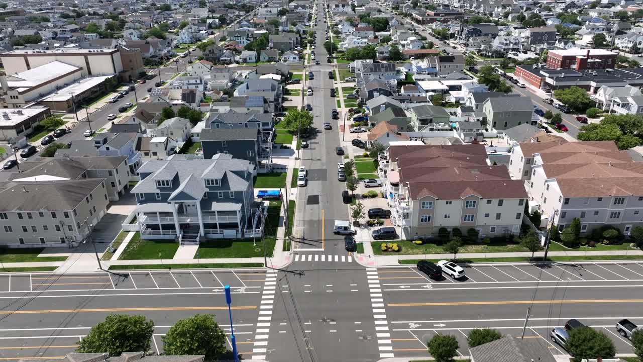 Luxury beach houses with swimming pool in garden in wildwood, New Jersey. Main Street and junction of small town. Aerial Birds Eye shot. Sunny summer day in America