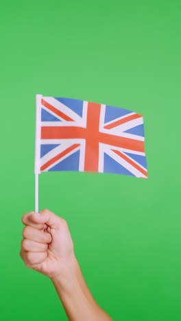 hand lifting a british pennant while waving by the wind