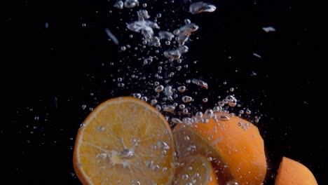 oranges falling into water super slowmotion, black background, lots of air bubbles, 4k240fps