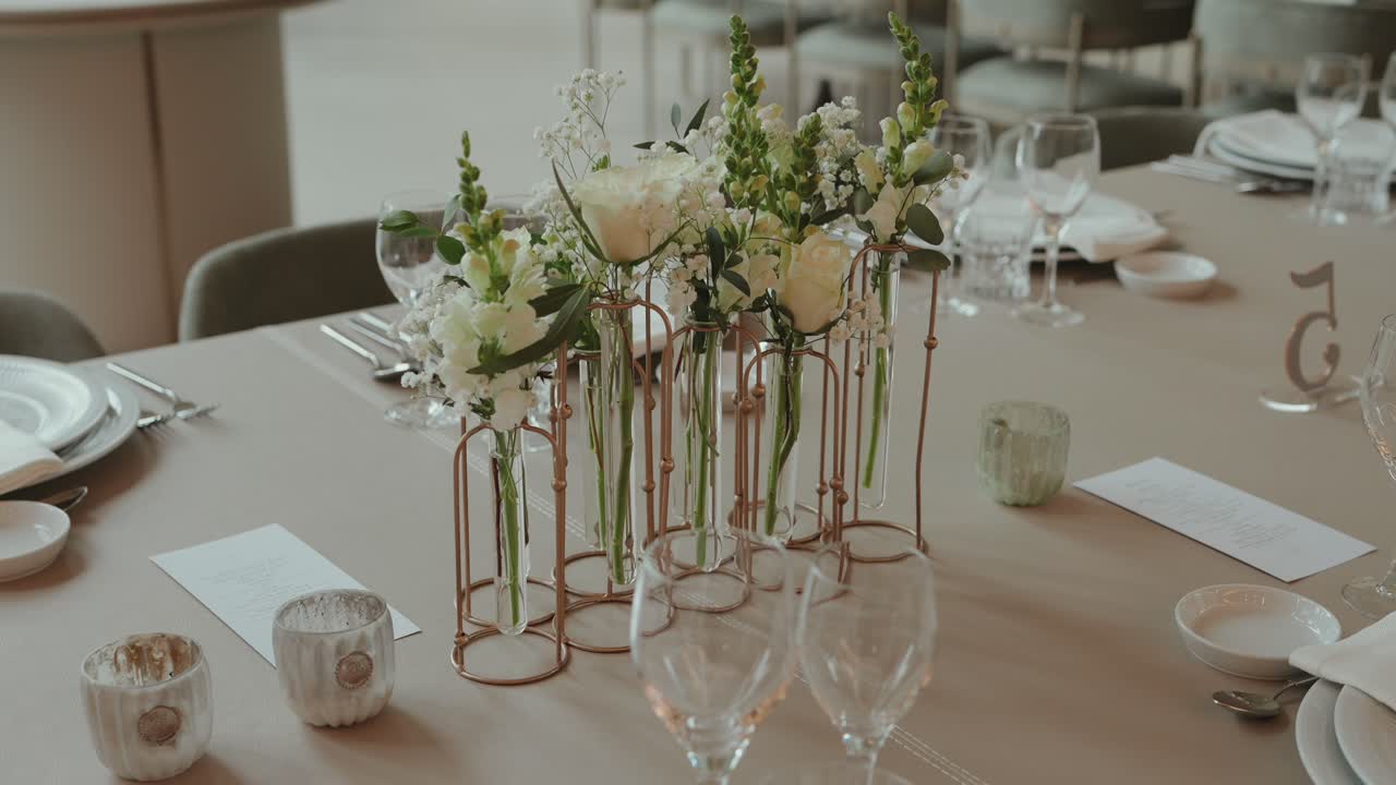 soft decor and floral vases arranged for a refined wedding reception