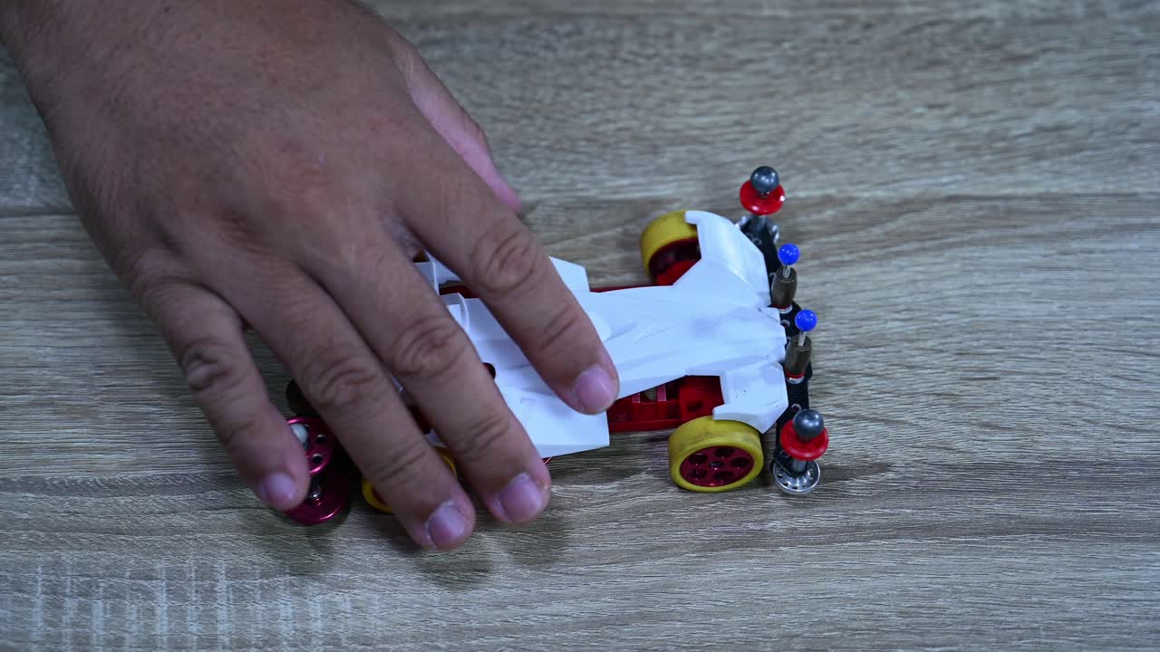 A hand lifting the car and drops it several times to check balance, Tamiya Mini 4WD, Hobby, mini 4WD racing