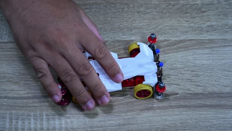 A-hand-lifting-the-car-and-drops-it-several-times-to-check-balance,-Tamiya-Mini-4WD,-Hobby,-mini-4WD-racing