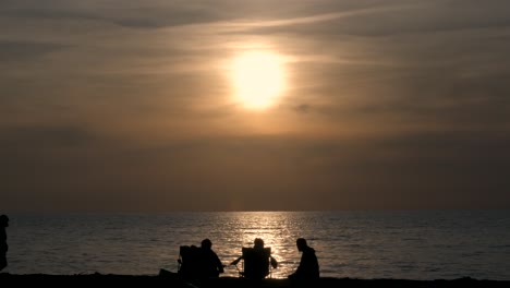 a family enjoying a beautiful sunset on potima beach, kissonerga village in cyprus