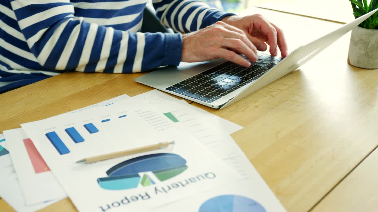 hombre de negocios analizando datos financieros y escribiendo en una computadora portátil