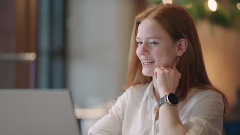 pretty young woman is communicating online by video call in laptop looking at web camera and smiling