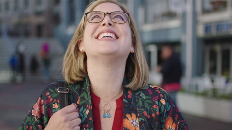 portrait-of-trendy-blonde-business-woman-laughing-happy-wearing-glasses-floral-shirt-enjoying-urban-travel