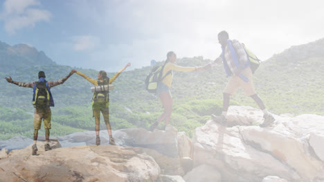 composite of happy african american couple hiking on rocks, and raising hands looking at the view