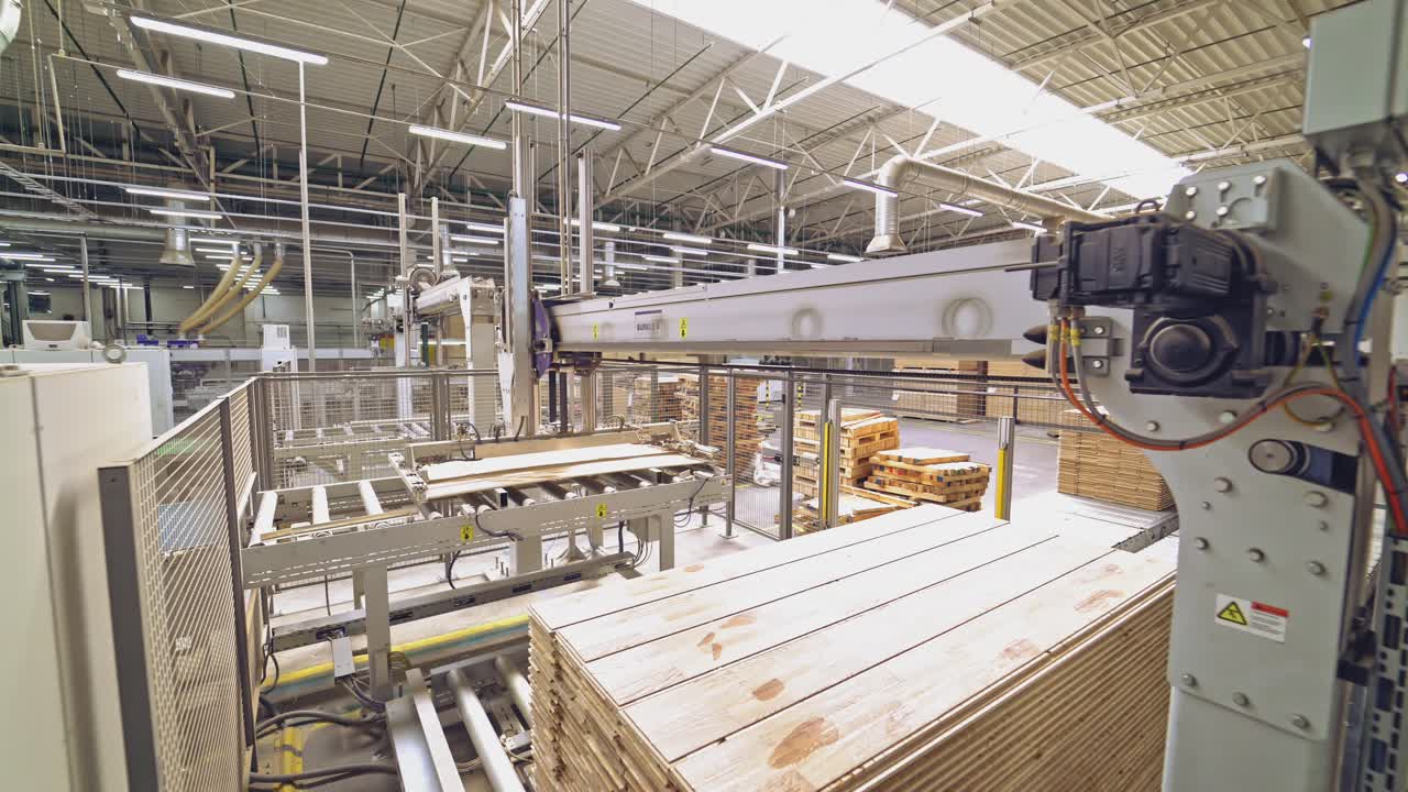 Polished wooden parquet passes the final stage of processing and a special device puts it on the stockpile. Parquet plant.