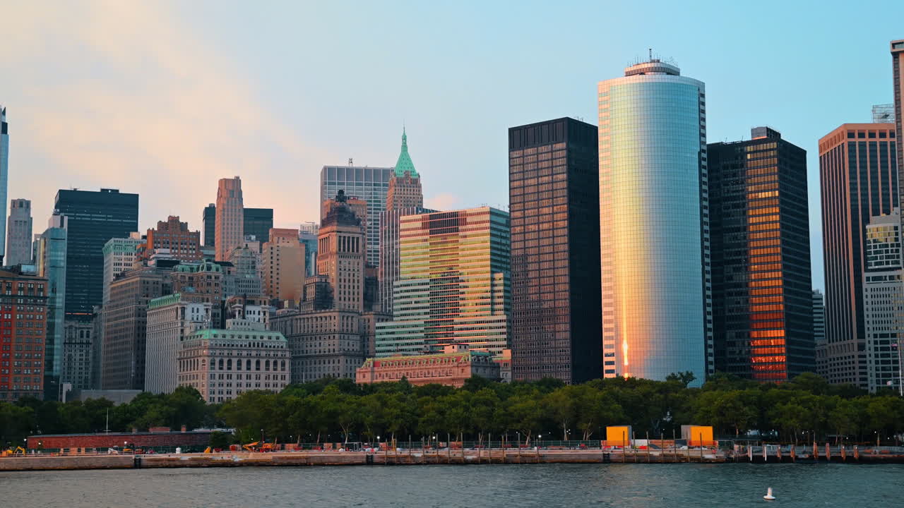 Horizonte de Manhattan com o One World Trade Center ao pôr do sol. Vista panorâmica dos arranha-céus de Nova Iorque a partir da água durante a hora dourada.
