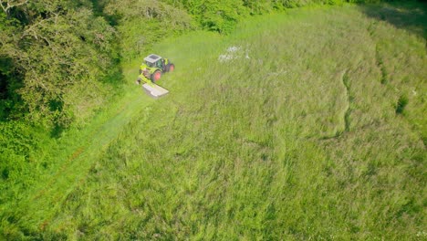 Luftaufnahme-Von-Oben-Nach-Unten-Eines-Traktors,-Der-An-Einem-Sonnigen-Tag-Gras-Auf-Dem-Feld-Schneidet,-Frankreich