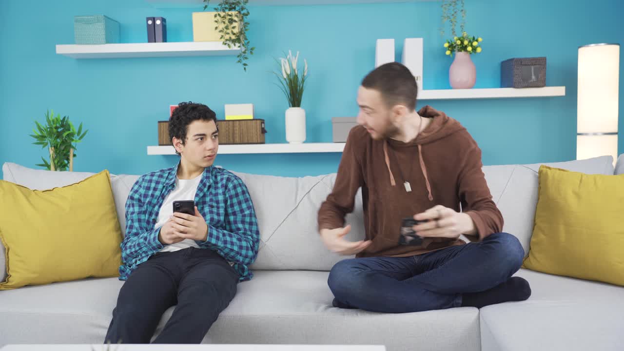 그 젊은이 는 좋은 소식 을 듣고 집 에서 어린 형제 와 함께 기 ⁇  을 나누고 있다.