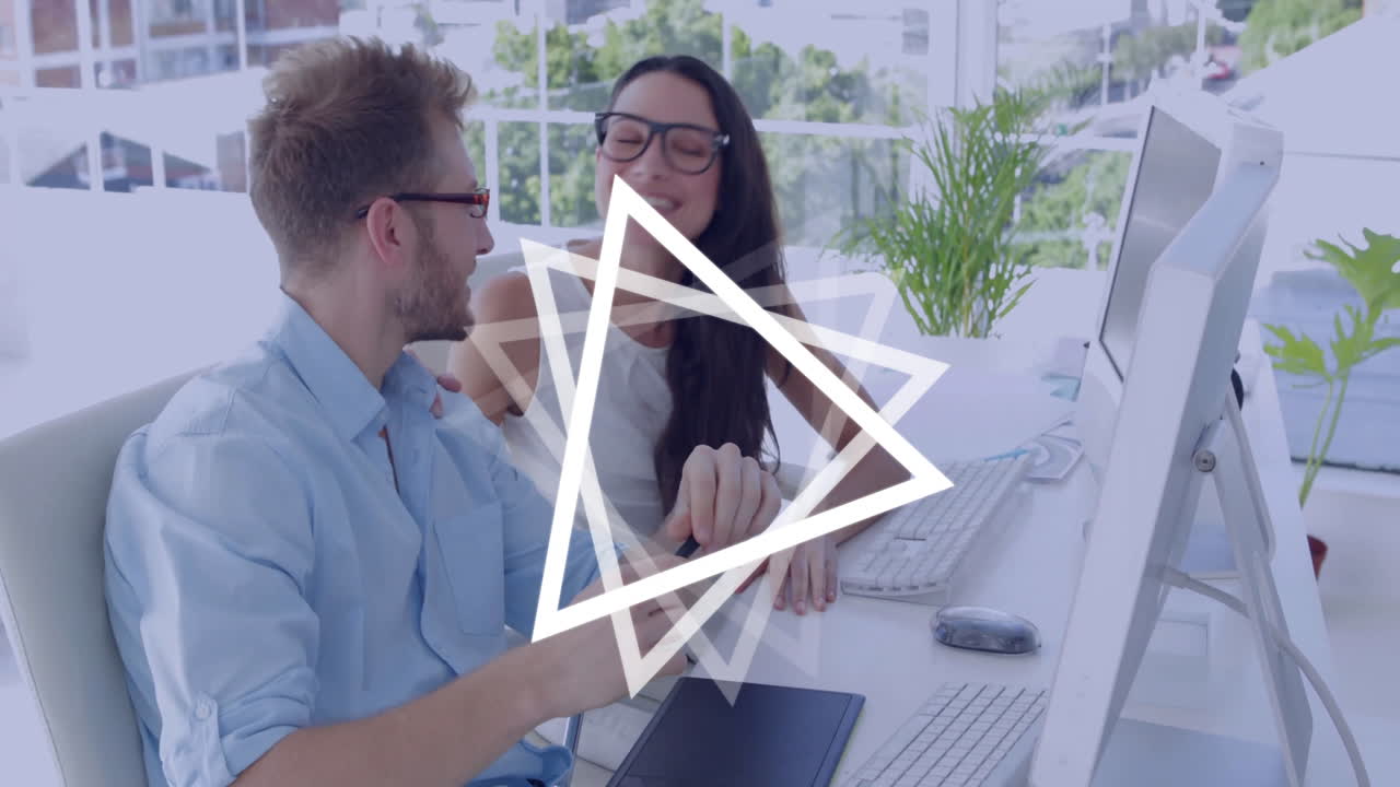 Man using digital tablet at desk with geometric animation overlay