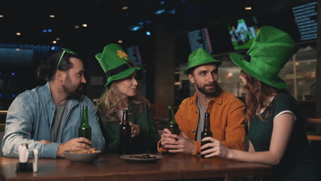 friends in irish hats celebrating saint patrick's day in a pub 1