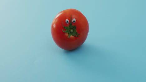 Video-Einer-Frischen-Tomate-Mit-Augen-Auf-Blauem-Hintergrund