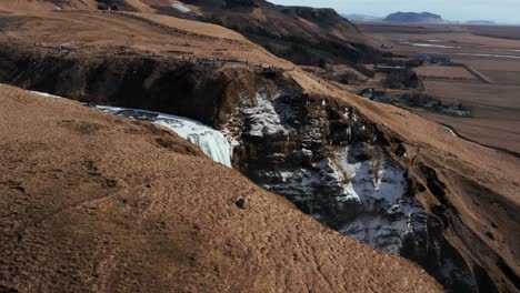 reveal shot of famous tourist attraction skogafoss waterfall in iceland