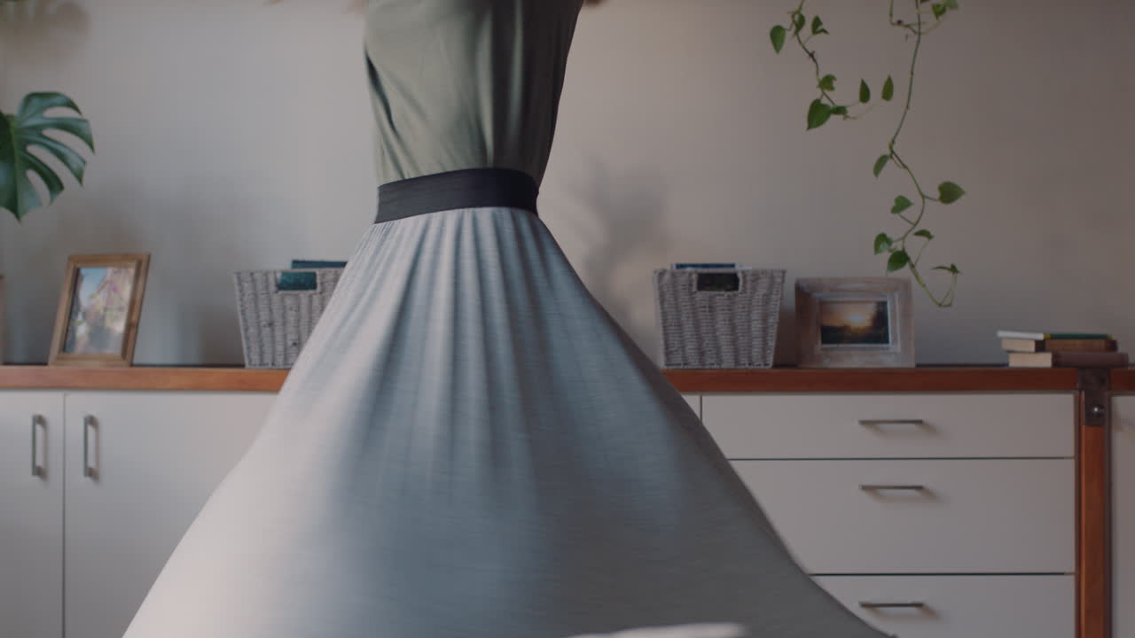 행복한 젊은 여성이 집에서 춤을 추고 즐겁게 여름 휴가를 축하하고 성공적인 라이프 스타일을 축하하기 위해 유쾌한 춤을 즐기고