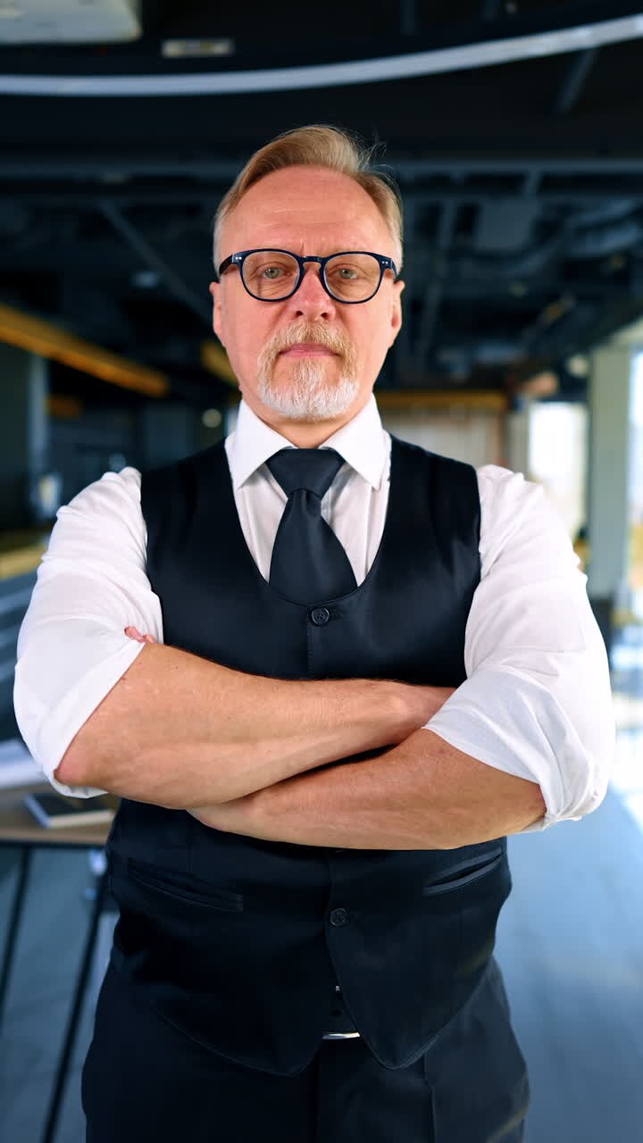 Uomo d'affari maturo e di successo. Un manager serio e affascinante in ufficio. Video verticale.
