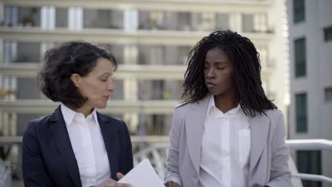 Serious-businesswomen-discussing-papers